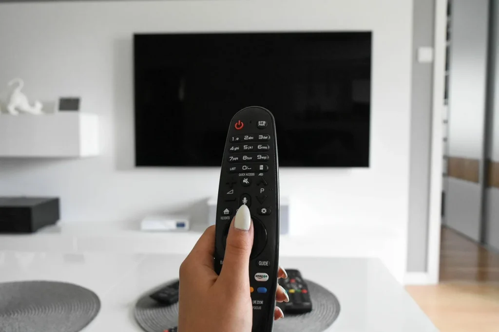 Fernseher im Wohnzimmer mit Fernbedienung – IPTV für Einsteiger übers Internet
